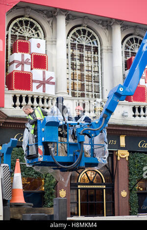 Les hommes de travail de mettre en place les décorations de Noël à la boutique Cartier à Londres Banque D'Images