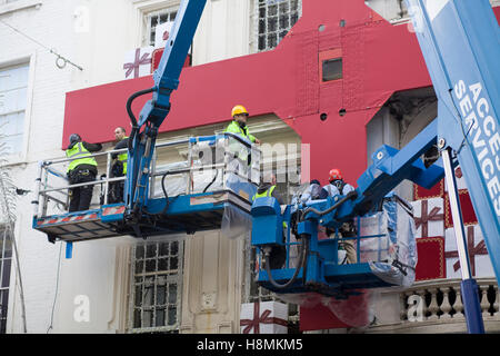 Les hommes de travail de mettre en place les décorations de Noël à la boutique Cartier à Londres Banque D'Images