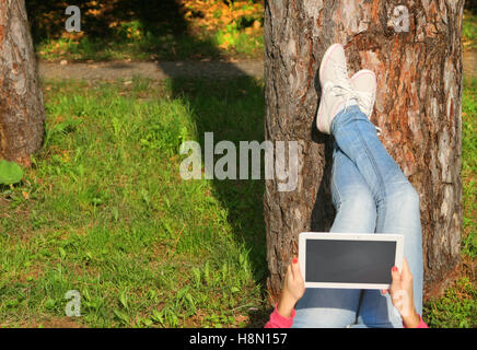 Woman using tablet pc in park Banque D'Images