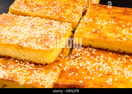 Tranche de gâteau au fromage avec graines de sésame sur un fond noir Banque D'Images