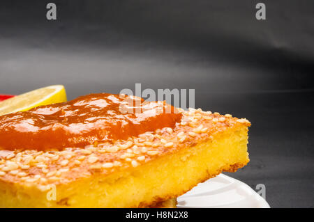 Tranche de gâteau au fromage avec des graines de sésame, confiture d'abricot et de tranches de citron sur un fond noir Banque D'Images