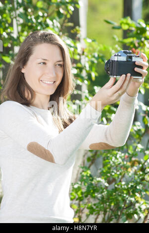 Jeune femme avec old vintage retro camera taking photo Banque D'Images