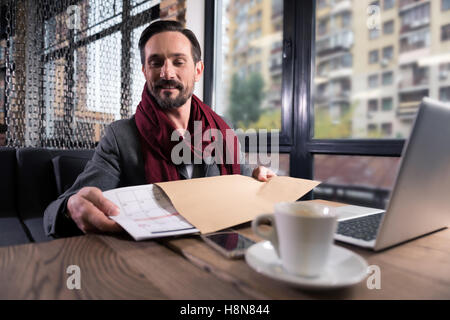 Bel homme optimiste mettant un calendrier dans l'enveloppe Banque D'Images