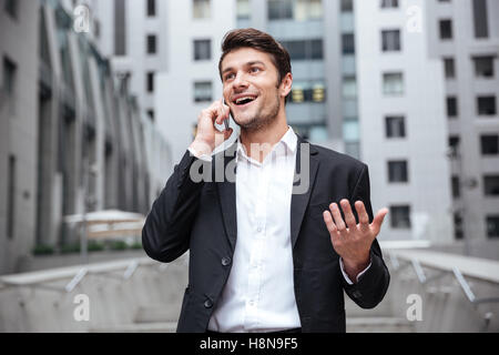 Happy young woman talking on mobile phone et dans la ville Banque D'Images