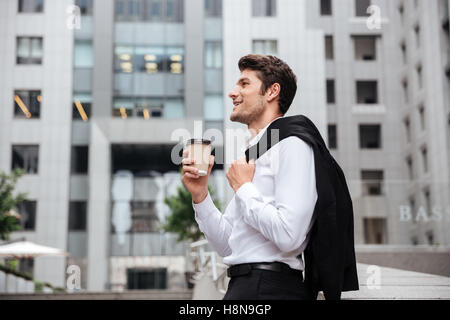 Cheerful young businessman de boire du café dans la ville Banque D'Images
