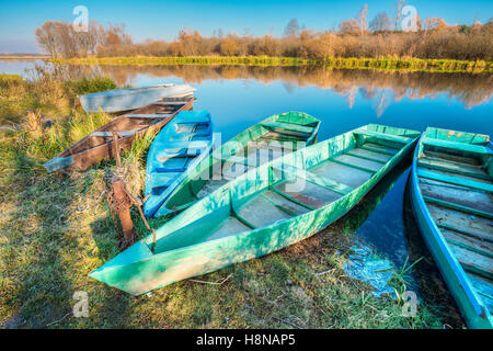 L'automne automne River Bank avec la location de chaloupes de pêche en bois ancienne Skippets, voguant sur la gauche de l'eau de la rivière immobile avec Ic Banque D'Images
