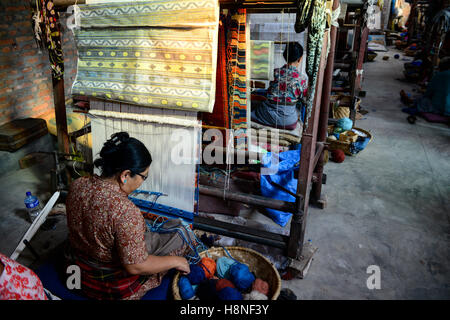 NÉPAL Katmandou, Lalitpur, camp de réfugiés tibétains Jawalakhel, usine de tapis JHC Jawalakhel Handicraft Center, femmes tibétaines réfugiées nouent des tapis au métier à tisser pour générer des revenus Banque D'Images