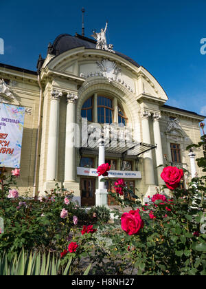 Roses rouges avec du Théâtre Dramatique de Chernivtsi Ukraine avant de Chernivtsi Drama Theatre dans l'arrière-plan. Oblast de Tchernivtsi Ukraine Banque D'Images