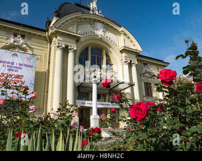 Roses rouges avec du Théâtre Dramatique de Chernivtsi Ukraine avant de Chernivtsi Drama Theatre dans l'arrière-plan. Oblast de Tchernivtsi Ukraine Banque D'Images