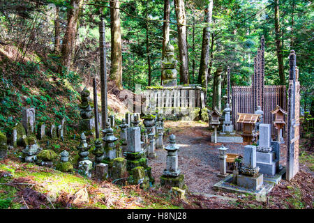 Le Japon, l'ancien cimetière Okunoin, Koyasan. Le dégagement en forêt de cèdres avec des pierres tombales, sotoba, lanternes en pierre et gorinto, cinq pagodes en pierre. Banque D'Images