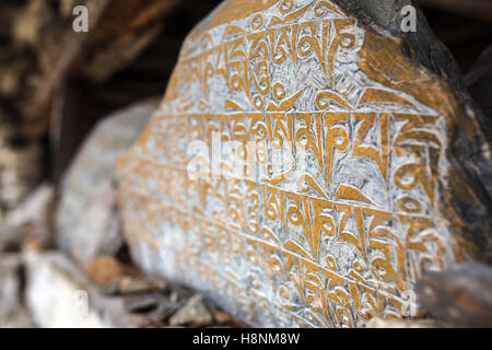 Malang, Népal - 6 mai 2016 : pierres mani dans village népalais, d'anciennes pierres sculptées bouddhiste avec mantras religieux sacré Banque D'Images