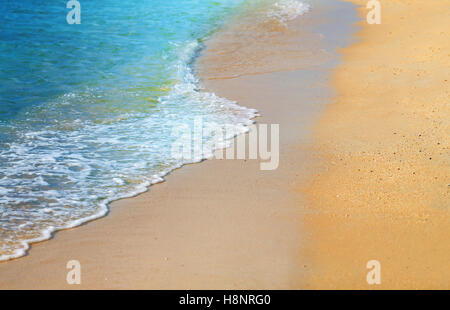 De belles vagues sur le sable de la mer jaune photographiée en close-up Banque D'Images