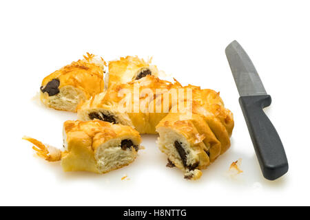 Morceaux de pain au lait à la noix de coco et le couteau sur fond blanc Banque D'Images