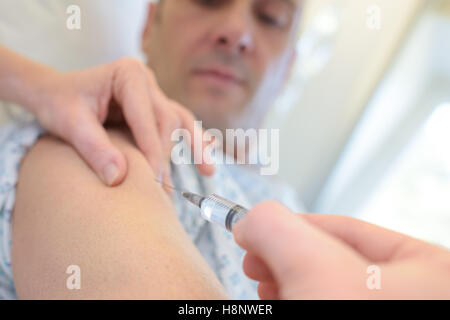Médecin met la seringue dans le bras masculin Banque D'Images