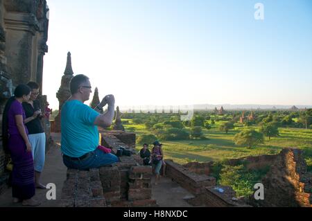 Bagan, Myanmar - le 12 novembre 2014. Les touristes de prendre des photos des pagodes dans la plaine de Bagan, Myanmar Banque D'Images