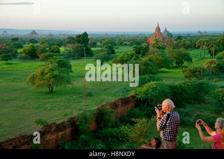 Bagan, Myanmar - le 12 novembre 2014. Les touristes photographiant la vue sur la plaine de Bagan au coucher du soleil. Banque D'Images