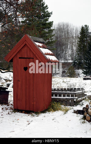 En bois rouge outhouse toilettes sur l'hiver. Banque D'Images