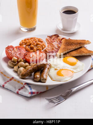 Le petit déjeuner anglais complet avec du bacon, saucisses, oeufs, haricots, champignons, sur tableau blanc Banque D'Images