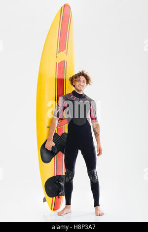 Portrait d'un jeune surfeur surf board holding heureux isolé sur fond blanc Banque D'Images
