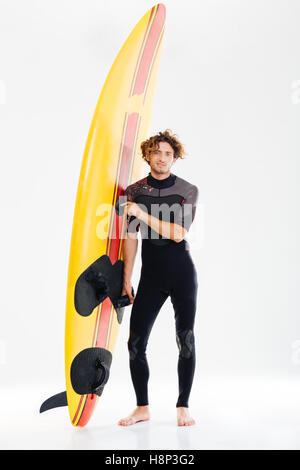 Portrait d'un jeune surfeur surf board holding heureux isolé sur fond blanc Banque D'Images