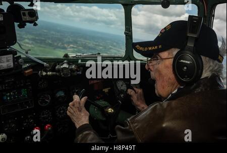 Ancien combattant de la Seconde Guerre mondiale Bill Version prend le contrôle de l'habitacle lors d'un vol à l'intérieur d'un C-47 Skytrain pour les bombardiers qui flottait au cours D-Day le 5 juin 2014 en Normandie, France. Banque D'Images