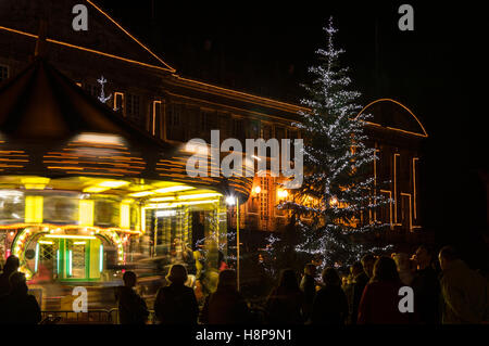 Les gens observant la déménagement carrousel avec décoration de Noël autour de (Couleur) Banque D'Images