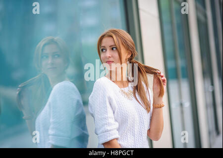 Belle femme se tient près d'une grande fenêtre de shop Banque D'Images