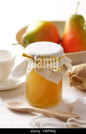 Un pot de confiture de poire fait maison et poires mûres sur une table de petit déjeuner. Banque D'Images