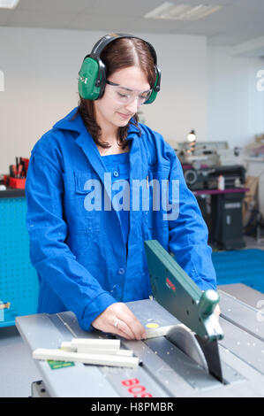 Jeune femme travaillant à un banc de scie circulaire Banque D'Images