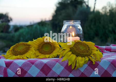Bocal en verre avec bougie allumée à l'intérieur et le tournesol Banque D'Images