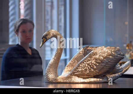 Un membre du personnel se penche sur une sculpture réalisée par swan Asprey &AMP ; Co comme un centre de table pour Rosalinde et Arthur Gilbert, exposée à l'intérieur du Victoria & Albert Museum ; de neuf Rosalinde et Arthur Gilbert galeries de Londres. Banque D'Images