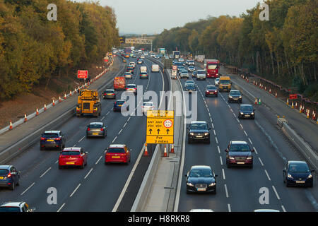 Voitures, camionnettes et camions traversent une zone de travaux routiers à 50mph sur l'autoroute M3 à Surrey, Angleterre, Grande-Bretagne. Banque D'Images