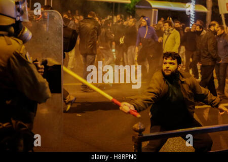 Athènes, Grèce. 15 Nov, 2016. Un manifestant s'attaque à un agent de police en tenue de combat avec un drapeau. Des milliers de manifestants ont suivi l'appel de l'Union communiste PAME et groupes anarchistes à venir dans les rues d'Athènes et de protestation contre la visite du président américain Barack Obama. La manifestation s'est terminée par des affrontements entre manifestants et la police anti-émeute. Les manifestants jettent des cocktails Molotov sur les policiers qui ont riposté avec des gaz lacrymogènes. Crédit : Michael Debets/Pacific Press/Alamy Live News Banque D'Images