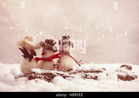 Les bonshommes ayant un gossip sur un journal couvert de neige Banque D'Images