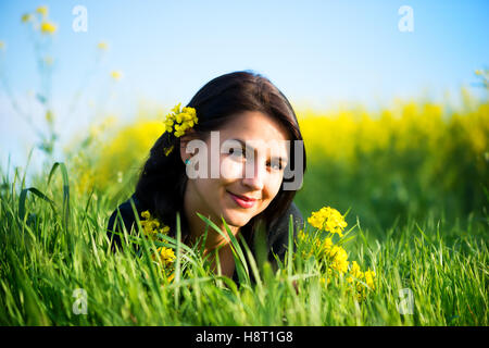 Portrait de belle jeune femme aux cheveux long lying in grass Banque D'Images