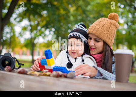 Mère avec son enfant jouer dans le parc et jouent avec des blocs Banque D'Images