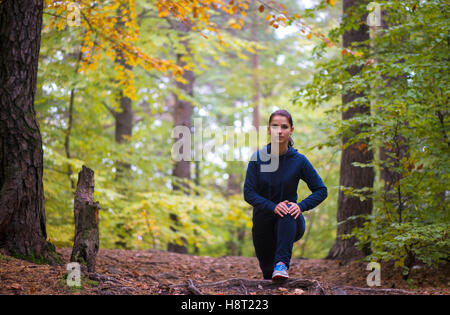 Jeune femme énergique de faire les exercices en plein air dans le parc de garder leur corps en forme Banque D'Images