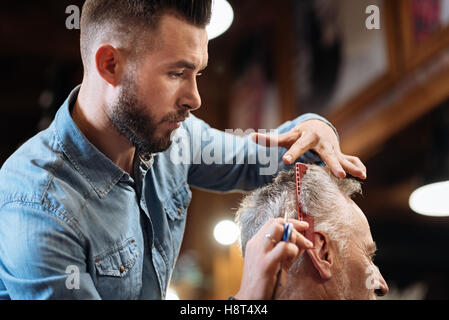 Low angle de handsome coiffure faire son travail Banque D'Images