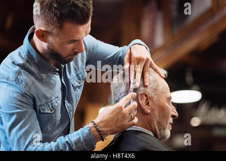 Low angle de handsome coiffure faire son travail Banque D'Images