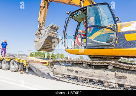 Zrenjanin, en Voïvodine, Serbie - 27 août 2015 : il monte sur l'excavatrice remorque plate-forme basse sur rampe arrière, transportant deux b Banque D'Images