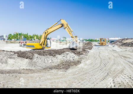 Vue sur chantier avec des machines, bulldozer est à niveau du site de construction. Transformation du paysage en grande région urbaine. Banque D'Images