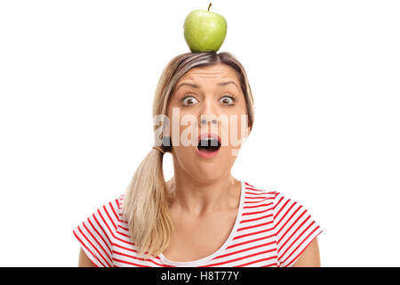 Jeune femme horrifiée d'une pomme sur sa tête isolé sur fond blanc Banque D'Images