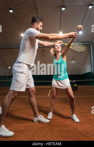 Compétent jeune insructor enseignant comment jouer au tennis Banque D'Images
