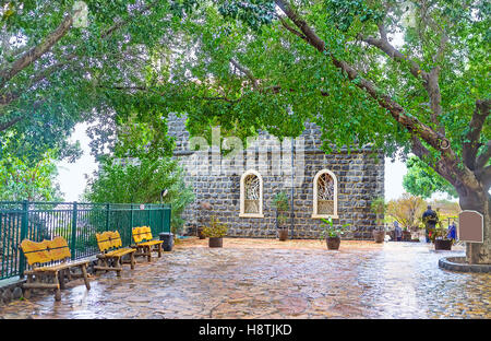 La façon d'église de la primauté de Saint Pierre se trouve à travers l'allée ombragée, Tabgha, Israël. Banque D'Images