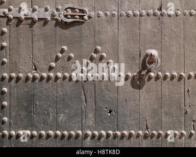 Fragment de l'ancienne porte en bois avec poignée rouillée et gros clous de fer Banque D'Images