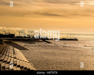 South Pier et plage plaisir Grande Ourse avec des marches en pierre de défense de la mer et de la mer d'Irlande en premier plan au coucher du soleil, Blackpool, Lancash Banque D'Images