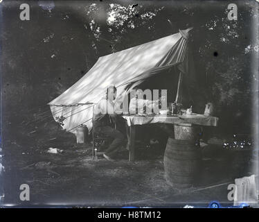 Meubles anciens c1910 photo, trois hommes, peut-être père et fils, camping avec petit déjeuner aux crêpes. Lieu inconnu, peut-être à Indianapolis, Indiana, USA. SOURCE : négatif photographique original. Banque D'Images