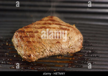 Un steak de boeuf à rôtir sur le gril Banque D'Images