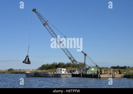 Les Broads Authority à l'aide d'une grue excavatrice pour draguer la rivière Bure sur les Norfolk Broads Banque D'Images