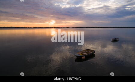 Image aérienne comme sunrise breaks sur deux petits bateaux de pêche à leurs amarres sur Passage Pumicestone à Golden Beach, Caloundra. Banque D'Images